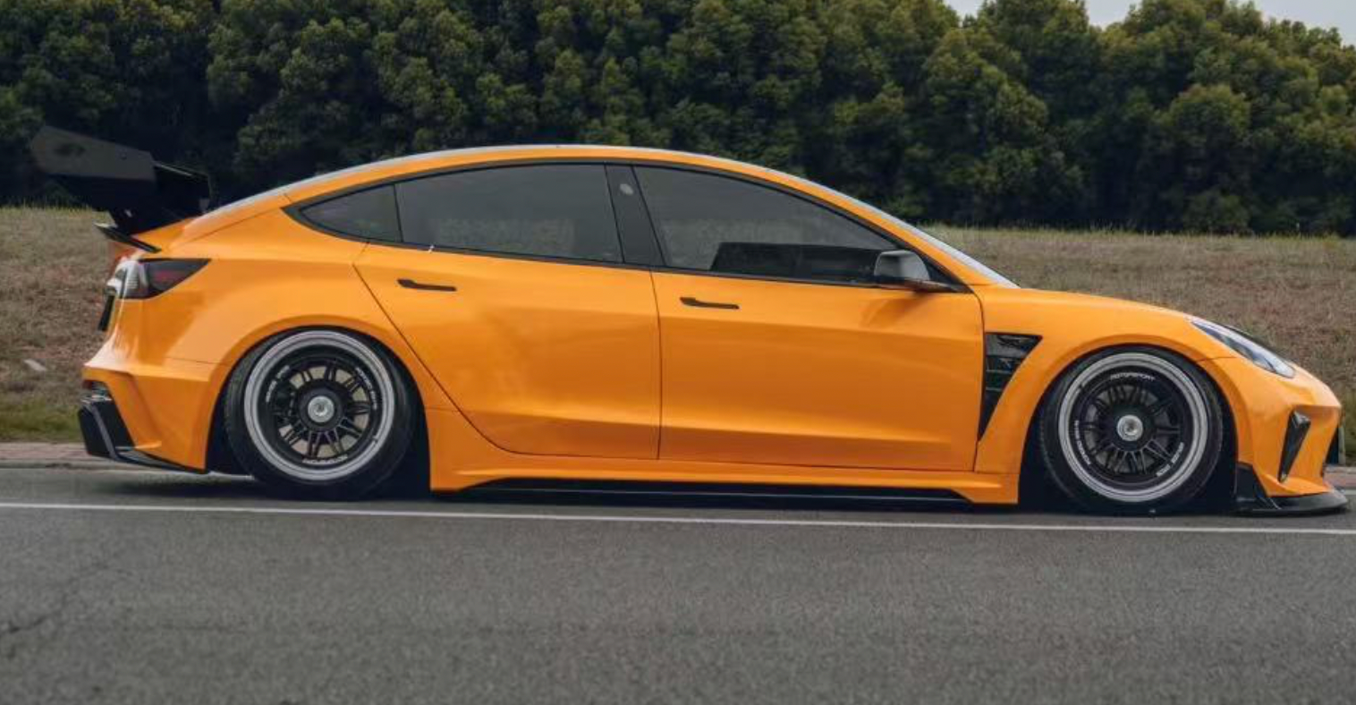 Tesla Model 3 in Orange und Tiefergelegt und von der Seitenansicht 